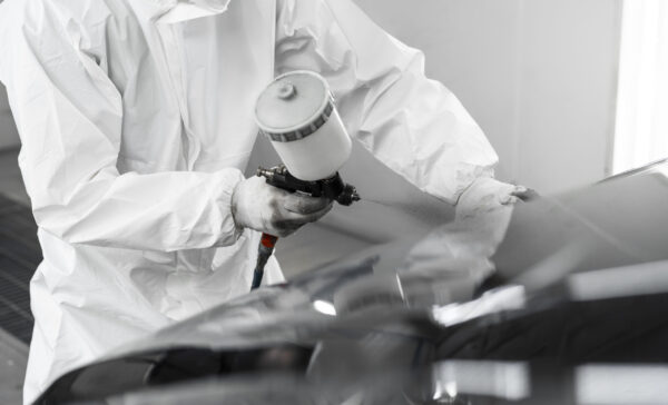 man-hazmat-suit-using-gun-paint-car-shop
